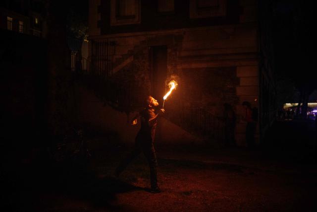 A fire-eater performs on the banks of the Seine River in Paris on May 20, 2026. (Photo by DIMITAR DILKOFF / AFP)