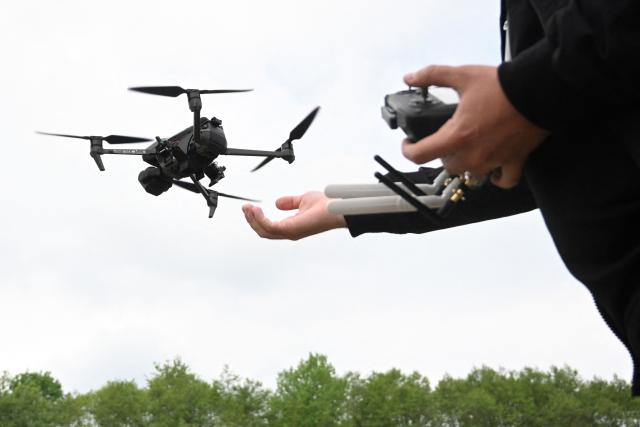 A man pilots a drone during the “Wild Drones” racing competition — designed to simulate battlefield conditions — in Truskavets, Lviv region, on May 20, 2026, amid Russia’s invasion of Ukraine. (Photo by YURIY DYACHYSHYN / AFP)