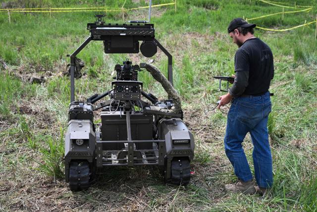 A man pilots an unmanned ground vehicle (UGV)  during the “Wild Drones” racing competition — designed to simulate battlefield conditions — in Truskavets, Lviv region, on May 20, 2026, amid Russia’s invasion of Ukraine. (Photo by YURIY DYACHYSHYN / AFP)