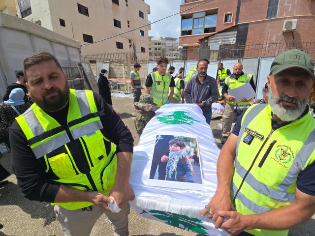 Officials carry the bodies of victims killed in the Israeli strike on the southern village of Deir Qanoun al-Nahr, outside Jabal Amel Hospital in the Tyre area of south Lebanon, before the bodies were transferred to their hometown for burial, as security conditions prevented families from holding the farewell ceremony in the village, on May 21, 2026. Israeli strikes on south Lebanon Tuesday killed 19 people, the Lebanese health ministry said, as Hezbollah reported clashes with Israeli troops despite a truce in the war. The ministry said 10 died in a strike on the town of Deir Qanun al-Nahr in the Tyre district, including three children and three women. (Photo by KAWANT HAJU / AFP)