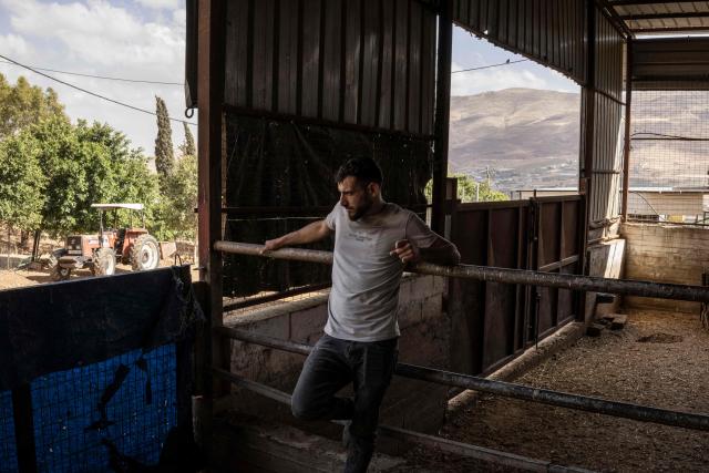 A Palestinian farmer stands in a sheep pen at a farm in the village of Nasariya in the occupied West Bank on May 20, 2026, ahead of Eid al-Adha, the Muslim Feast of Sacrifice. Eid al-Adha marks the end of the Hajj pilgrimage to Mecca and commemorates the Prophet Abrahams willingness to sacrifice his son as an act of obedience to Allah, with the ritual centred on the slaughter of livestock. For Palestinian farmers in the occupied West Bank, the pastoral tradition linked to the festival is increasingly constrained as grazing areas have significantly shrunk amid the expansion of Israeli settlements. Many now rely more heavily on purchased fodder to feed their animals year-round, while also stepping up farm security amid rising reports of livestock theft. (Photo by JOHN WESSELS / AFP)