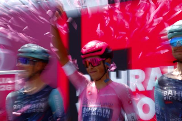 Bahrain - Victorious Portuguese rider Afonso Eulalio wearing the overall leader's pink jersey waves on stage before the 12th stage of the Giro d'Italia 2026 - Tour of Italy cycling race between Imperia and Novi Ligure, Italy, on May 21, 2026. (Photo by Luca Bettini / AFP)