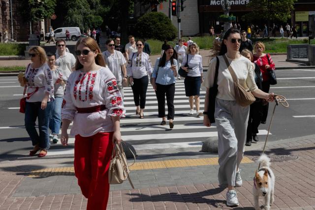 Local residents wearing a vyshyvanka are crossing the street on Vyshyvanka Day in Kyiv on May 21, 2026, amid the Russian invasion of Ukraine. (Photo by Tetiana DZHAFAROVA / AFP)