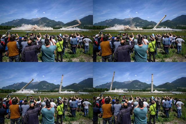 (COMBO) This combination of pictures created on May 21, 2026 shows people watching the controlled demolition by explosion of the two 100-metre-high chimneys of a former refinery in Collombey-Muraz, south-western Switzerland, on May 21, 2026. Constructed by Eni, the Collombey refinery operated from 1963 to late March 2015 was closed after more than 50 years under Tamoil ownership. (Photo by Fabrice COFFRINI / AFP)