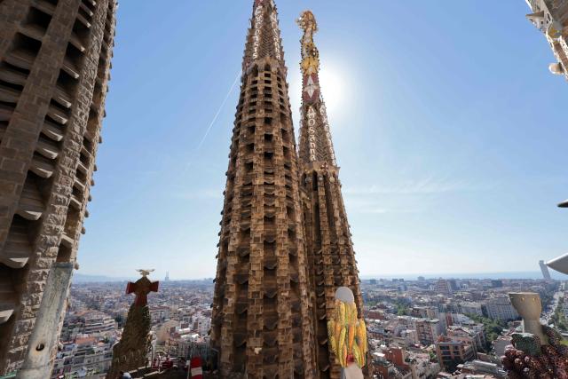 Two of eighteen spires of the Sagrada Familia basilica are seen from the top of the basilica on May 21, 2026 in Barcelona. The Sagrada Familia basilica's central tower's cross crowns the world's tallest church at 172.5 meters, a temple conceived by Antoni Gaudi more than 140 years ago. (Photo by Thomas COEX / AFP)