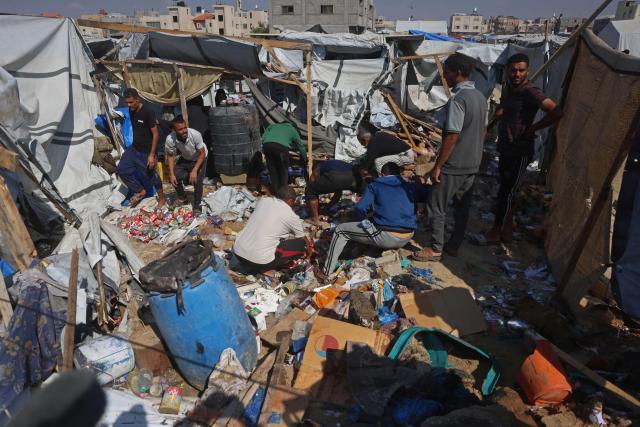 Displaced Palestinians inspect the site of an Israeli strike that targeted a food distribution tent in the Mawasi area of Khan Yunis, in the southern Gaza Strip on May 21, 2026. The war was sparked by Hamas's October 7, 2023 attack on Israel, which resulted in the deaths of 1,221 people. Israel's retaliatory assault on Gaza has killed at least 72,736 people, according to figures from the health ministry that the UN considers reliable. (Photo by Bashar Taleb / AFP)