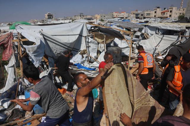 Displaced Palestinians inspect the site of an Israeli strike that targeted a food distribution tent in the Mawasi area of Khan Yunis, in the southern Gaza Strip on May 21, 2026. The war was sparked by Hamas's October 7, 2023 attack on Israel, which resulted in the deaths of 1,221 people. Israel's retaliatory assault on Gaza has killed at least 72,736 people, according to figures from the health ministry that the UN considers reliable. (Photo by Bashar Taleb / AFP)