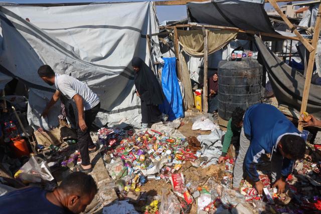 Displaced Palestinians inspect the site of an Israeli strike that targeted a food distribution tent in the Mawasi area of Khan Yunis, in the southern Gaza Strip on May 21, 2026. The war was sparked by Hamas's October 7, 2023 attack on Israel, which resulted in the deaths of 1,221 people. Israel's retaliatory assault on Gaza has killed at least 72,736 people, according to figures from the health ministry that the UN considers reliable. (Photo by Bashar Taleb / AFP)