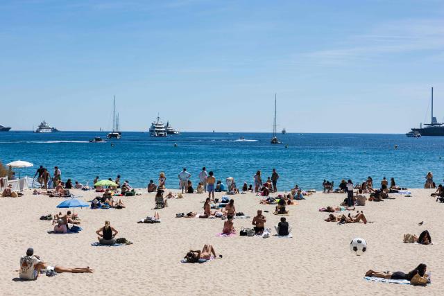 Beachogoers enjoy the sun on Plage Mace beach on the sidelines of the 79th edition of the Cannes Film Festival in Cannes, southern France, on May 21, 2026. (Photo by SAMEER AL-DOUMY / AFP)