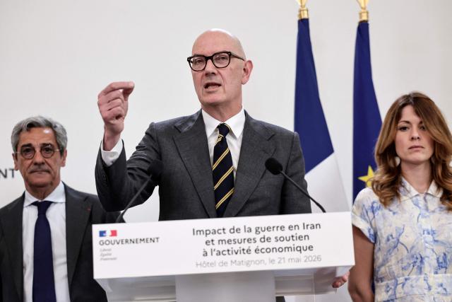 France's Economy, Finances and Industry Minister Roland Lescure (C) speaks as France's Trade Minister Serge Papin (L) and France's Government Spokesperson and junior Minister for Energy and Digital economy Maud Bregeon (R) listen, during a press conference focusing on the consequences of the war in Iran and to announce "measures to support economic activity", at the Hotel Matignon Prime minister residence in Paris on May 21, 2026. The message en the screen on the right reads in French "A clear principle for the next budget: no tax increases". (Photo by STEPHANE DE SAKUTIN / AFP)