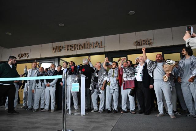 Members of the Global Sumud Flotilla headed for Gaza and arrested and deported by Israel pose outside a terminal following their arrival at Istanbul Airport on May 21, 2026. The first of hundreds of Gaza flotilla activists began arriving at Istanbul airport on may 21  after being arrested then deported from Israel, an AFP correspondent said. The 422 activists, who were flown from southern Israel on three planes chartered by Ankara, had been part of a fleet of around 50 vessels that set sail from southern Turkey on May 14 seeking to break Israel's blockade on Gaza, which was joined at sea by several others. (Photo by Ozan KOSE / AFP)