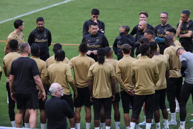 Lens' French head coach Pierre Sage (C) speaks to his players during a training session on the eve of the French Cup final football match between Nice (OGC) and Lens (RC) at the Stade de France stadium, in Saint-Denis, on the outskirts of Paris, on May 21, 2026. Lens wants to write one of the finest chapters in its history by winning its first French Cup on May 22, 2026, against Nice, which will above all be looking to regain confidence a few days before decisive play-offs for its survival in Ligue 1. (Photo by FRANCK FIFE / AFP)
