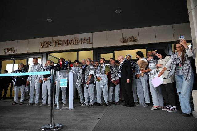 Members of the Global Sumud Flotilla headed for Gaza and arrested and deported by Israel pose outside a terminal following their arrival at Istanbul Airport on May 21, 2026. The first of hundreds of Gaza flotilla activists began arriving at Istanbul airport on may 21  after being arrested then deported from Israel, an AFP correspondent said. The 422 activists, who were flown from southern Israel on three planes chartered by Ankara, had been part of a fleet of around 50 vessels that set sail from southern Turkey on May 14 seeking to break Israel's blockade on Gaza, which was joined at sea by several others. (Photo by Ozan KOSE / AFP)