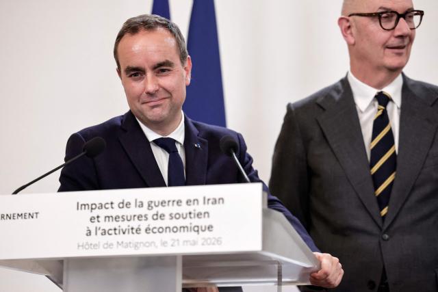 France's Prime Minister Sebastien Lecornu (L) smiles next to France's Economy, Finances and Industry Minister Roland Lescure (R) during a press conference focusing on the consequences of the war in Iran and to announce "measures to support economic activity", at the Hotel Matignon Prime minister residence in Paris on May 21, 2026. (Photo by STEPHANE DE SAKUTIN / AFP)