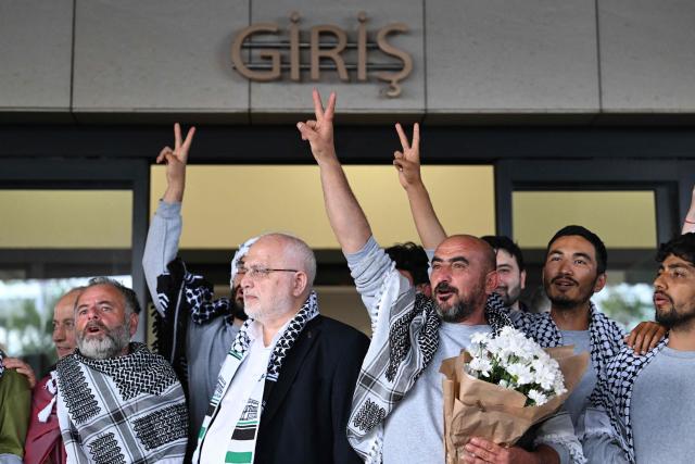 Members of the Global Sumud Flotilla headed for Gaza and arrested and deported by Israel pose outside a terminal following their arrival at Istanbul Airport on May 21, 2026. The first of hundreds of Gaza flotilla activists began arriving at Istanbul airport on may 21  after being arrested then deported from Israel, an AFP correspondent said. The 422 activists, who were flown from southern Israel on three planes chartered by Ankara, had been part of a fleet of around 50 vessels that set sail from southern Turkey on May 14 seeking to break Israel's blockade on Gaza, which was joined at sea by several others. (Photo by Ozan KOSE / AFP)