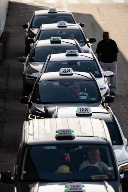 (FILES) This photographs shows taxis waiting for passengers at the Marseille cruise terminal in the Grand Port Maritime de Marseille, in Marseille, south-eastern France on April 11, 2026. Taxi drivers in France will be eligible "from October 1, 2026" for a purchase subsidy "of up to Ђ5,500 for an electric vehicle", France's Transport Minister announced on May 21, 2026, during a government press conference on the economic consequences of the war in the Middle East. (Photo by CLEMENT MAHOUDEAU / AFP)