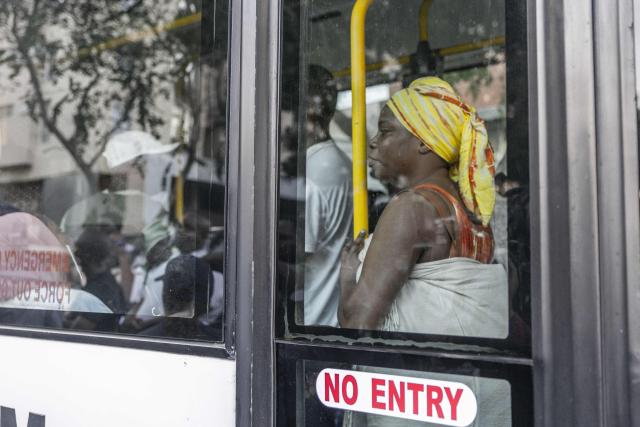 Foreign nationals who say they have no safe place to return to and are appealing for help from the South African government are seen being transported from the Diakonia Centre to the Home Affairs offices in Durban on May 21, 2026. The crowd, made up largely of refugees and foreign nationals had been sheltering at the station for up to two days, seeking police protection amid threats and intimidation. Their presence came against the backdrop of sporadic anti-illegal immigration protests that have unsettled parts of South Africa in recent weeks. (Photo by RAJESH JANTILAL / AFP)