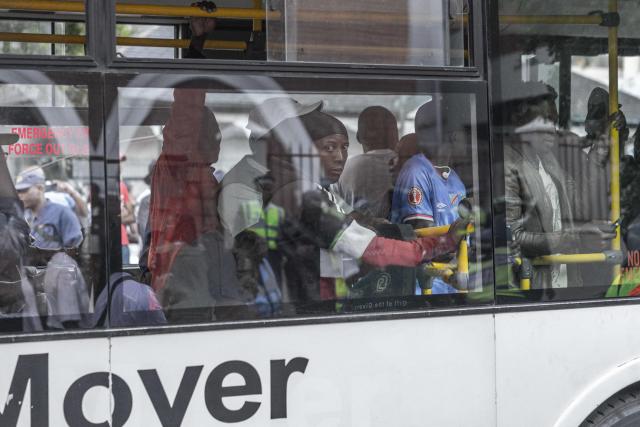 Foreign nationals who say they have no safe place to return to and are appealing for help from the South African government are seen being transported from the Diakonia Centre to the Home Affairs offices in Durban on May 21, 2026. The crowd, made up largely of refugees and foreign nationals had been sheltering at the station for up to two days, seeking police protection amid threats and intimidation. Their presence came against the backdrop of sporadic anti-illegal immigration protests that have unsettled parts of South Africa in recent weeks. (Photo by RAJESH JANTILAL / AFP)
