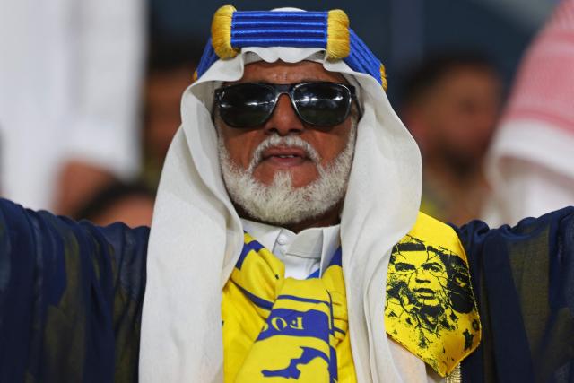 A fan wears a scarf with a picture of Nassr's Portuguese forward #07 Cristiano Ronaldo before the start of the Saudi Pro League football match between Al-Nassr and Damac at the Al-Awwal Park Stadium in Riyadh on May 21, 2026. (Photo by Fayez NURELDINE / AFP)