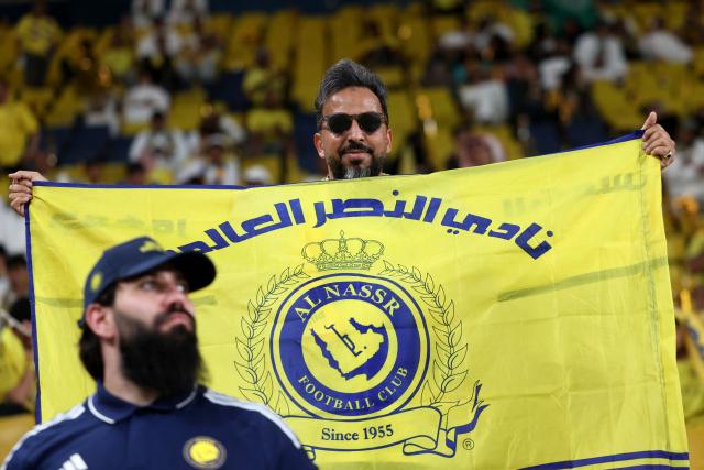 A fan of Al-Nassr holds the team's flag before the start of the Saudi Pro League football match between Al-Nassr and Damac at the Al-Awwal Park Stadium in Riyadh on May 21, 2026. (Photo by Fayez NURELDINE / AFP)