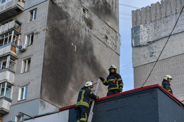 Rescuers work near a damaged residential building following an air attack in Dnipro on May 21, 2026, amid the Russian invasion of Ukraine. (Photo by Mykola SYNELNYKOV / AFP)