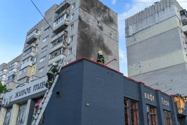 Rescuers work near a damaged residential building following an air attack in Dnipro on May 21, 2026, amid the Russian invasion of Ukraine. (Photo by Mykola SYNELNYKOV / AFP)