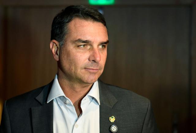 (FILES) Brazilian Senator and pre-presidential candidate Flavio Bolsonaro looks on as he speaks with the press during a meeting with businessmen at a hotel in Rio de Janeiro, Brazil on March 19, 2026. When opinion polls appeared favorable, the scandal broke: Flavio Bolsonaro, the right-wing candidate in Brazil's October presidential election, had dealings with a banker jailed for alleged fraud, threatening to complicate his race against President Lula. The 45-year-old senator was chosen as the political heir by his father, former far-right president Jair Bolsonaro, who was convicted over an attempted coup and barred from running for office. (Photo by Daniel RAMALHO / AFP)