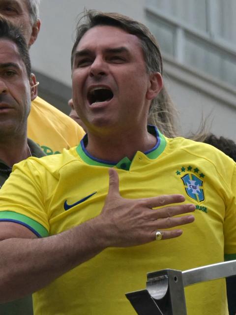 (FILES) Senator and presidential candidate Flavio Bolsonaro gestures to supporters of Brazil's former president Jair Bolsonaro (2019-2022), sentenced to 23 years and 3 months for attempted coup, during a demonstration in Sao Paulo, Brazil, on March 1, 2026. When opinion polls appeared favorable, the scandal broke: Flavio Bolsonaro, the right-wing candidate in Brazil's October presidential election, had dealings with a banker jailed for alleged fraud, threatening to complicate his race against President Lula. The 45-year-old senator was chosen as the political heir by his father, former far-right president Jair Bolsonaro, who was convicted over an attempted coup and barred from running for office. (Photo by NELSON ALMEIDA / AFP)