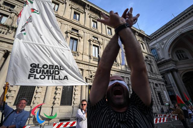 People take part in a flash mob entitled "In the same boat" to protest against the detention and treatment by Israel of activists participating in the Global Sumud Flotilla,
in Milan, northern Italy, on May 21, 2026.. Hundreds of activists from countries around the world were placed in detention in Israel after they were intercepted at sea on May 18 while making the latest in a string of attempts to break the blockade of the Palestinian territory. Israel's far-right National Security Minister Itamar Ben Gvir sparked widespread condemnation and diplomatic backlash on May 20 by posting a video showing the detained activists with their hands tied and foreheads on the ground. (Photo by Piero CRUCIATTI / AFP)