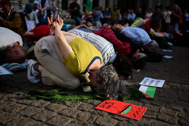 People take part in a flash mob entitled "In the same boat" to protest against the detention and treatment by Israel of activists participating in the Global Sumud Flotilla,
in Milan, northern Italy, on May 21, 2026.. Hundreds of activists from countries around the world were placed in detention in Israel after they were intercepted at sea on May 18 while making the latest in a string of attempts to break the blockade of the Palestinian territory. Israel's far-right National Security Minister Itamar Ben Gvir sparked widespread condemnation and diplomatic backlash on May 20 by posting a video showing the detained activists with their hands tied and foreheads on the ground. (Photo by Piero CRUCIATTI / AFP)