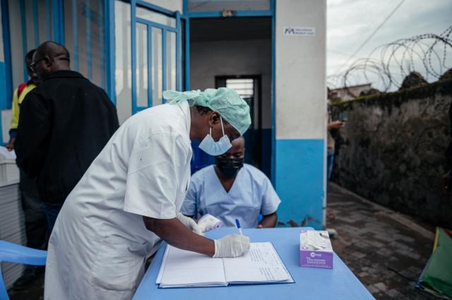 A doctor from CBCA Virunga hospital prepares to check and register visitors temperature at a screening checkpoint set up at the hospital entrance as part of Ebola prevention measures in Goma, on May 21, 2026. An Ebola outbreak in the Democratic Republic of Congo has spread to eastern South Kivu province in an area under the control of the Rwanda-backed M23 militia, the group's spokesman said Thursday, heightening fears of the deadly disease's growing reach.
Efforts to get a grip on the latest outbreak of the highly contagious haemorrhagic fever, which the World Health Organization has declared an international emergency, have been hampered by the DRC's long-running conflicts, including between the Congolese army and the M23. Having seized swathes of land in the mineral-rich east with Rwanda's help, the M23 has installed a parallel administration to the Congolese government in areas under its control. (Photo by Jospin Mwisha / AFP)
