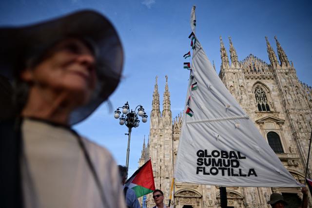 People take part in a flash mob entitled "In the same boat" to protest against the detention and treatment by Israel of activists participating in the Global Sumud Flotilla,
in Milan, northern Italy, on May 21, 2026.. Hundreds of activists from countries around the world were placed in detention in Israel after they were intercepted at sea on May 18 while making the latest in a string of attempts to break the blockade of the Palestinian territory. Israel's far-right National Security Minister Itamar Ben Gvir sparked widespread condemnation and diplomatic backlash on May 20 by posting a video showing the detained activists with their hands tied and foreheads on the ground. (Photo by Piero CRUCIATTI / AFP)
