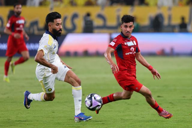 Nassr's Saudi defender #12 Nawaf Boushal (L) and Damac's Saudi defender #20 Dhari Al-Anazi run for the ball during the Saudi Pro League football match between Al-Nassr and Damac at the Al-Awwal Park Stadium in Riyadh on May 21, 2026. (Photo by Fayez NURELDINE / AFP)