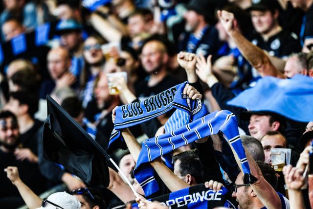 Club Bruggge fans cheer on including one brandishing a club scarf ahead of the Belgian "Pro League" First Division football match between KV Mechelen and Club Brugge at Achter De Kazerne stadium in Mechelen on May 21, 206. (Photo by BRUNO FAHY / BELGA / AFP) / Belgium OUT