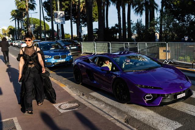 A pedestrian walk alongside a Lamborghini on the Boulevard de la Croisette on the sidelines of the 79th edition of the Cannes Film Festival in Cannes, southern France on May 21, 2026. (Photo by SAMEER AL-DOUMY / AFP)
