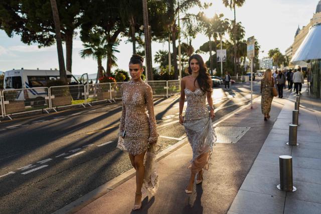 Pedestrians in evening attire walk along the Boulevard de la Croisette on the sidelines of the 79th edition of the Cannes Film Festival in Cannes, southern France on May 21, 2026. (Photo by SAMEER AL-DOUMY / AFP)