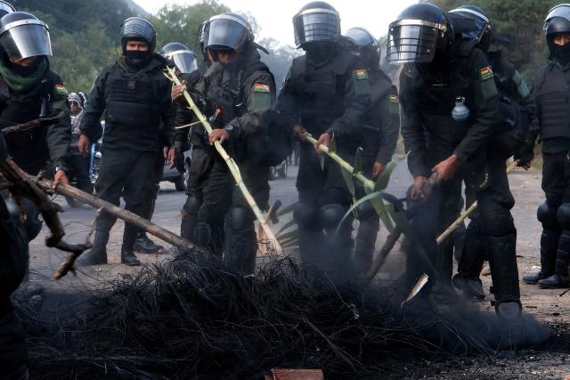 Bolivian police officers clear a blockade on the road between Cochabamba and La Paz during a protest by social movements calling for the resignation of President Rodrigo Paz near Parotani, Bolivia on May 21, 2026. Bolivia's centre-right President Rodrigo Paz announced on May 20 that he will make changes to his cabinet to include social sectors, in an attempt to quell protests demanding his resignation just six months after taking office. (Photo by David FLORES / AFP)