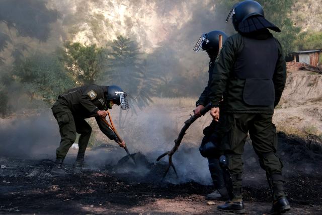 Bolivian police officers clear a blockade on the road between Cochabamba and La Paz during a protest by social movements calling for the resignation of President Rodrigo Paz near Parotani, Bolivia on May 21, 2026. Bolivia's centre-right President Rodrigo Paz announced on May 20 that he will make changes to his cabinet to include social sectors, in an attempt to quell protests demanding his resignation just six months after taking office. (Photo by David FLORES / AFP)