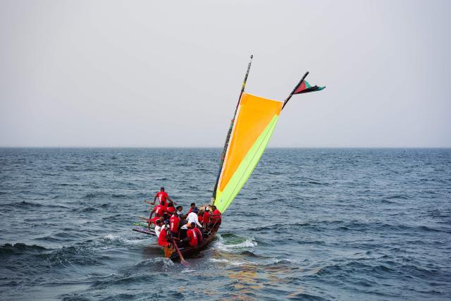 Local officials and members of a Martinican delegation sail on a Martinican yole, a wooden sailboat unique to Martinique, during a commemoration event marking the abolition of slavery and the 50th anniversary of the historic meeting between Leopold Sedar Senghor and Aime Cesaire on Goree Island, Dakar, on May 21, 2026. (Photo by Lisa Coulaud / AFP)