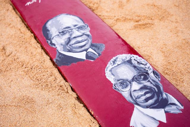 Paintings depicting former Senegalese President Leopold Sedar Senghor (L) and former President of the Regional Council of Martinique Aime Cesaire (R), are seen on a wooden paddle during a commemoration event marking the abolition of slavery and the 50th anniversary of the historic meeting between Leopold Sedar Senghor and Aime Cesaire on Goree Island, Dakar, on May 21, 2026. (Photo by Lisa Coulaud / AFP)