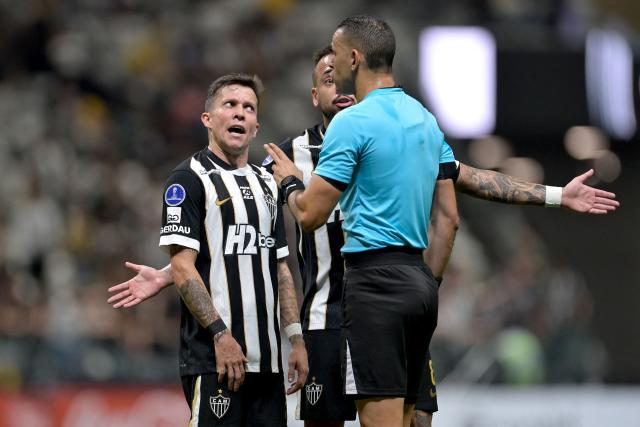 Atletico Mineiro's midfielder #11 Bernard talks to Colombian referee Carlos Ortega during the Copa Sudamericana group stage football match between Brazil's Atletico Mineiro and Peru's Cienciano at Arena MRV stadium in Belo Horizonte, Minas Gerais state, Brazil on May 21, 2026. (Photo by DOUGLAS MAGNO / AFP)