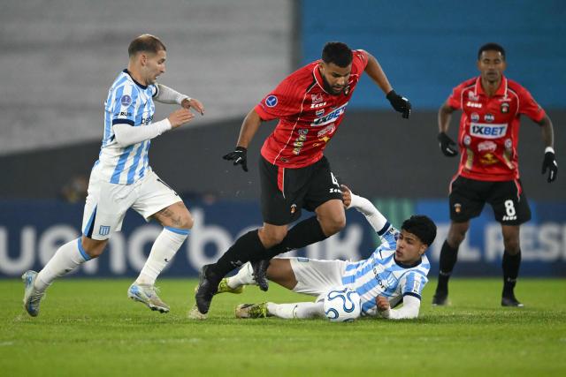 Racing's US midfielder #10 Matko Miljevic (L), Caracas' defender #04 Jesus Quintero (C), and Racing's forward #58 Tomas Perez (2nd-R) fight for the ball during the Copa Sudamericana group stage football match between Argentina's Racing Club and Venezuela's Caracas FC at Presidente Peron 'El Cilindro' stadium in Avellaneda, Buenos Aires province, Argentina on May 21, 2026. (Photo by Luis ROBAYO / AFP)