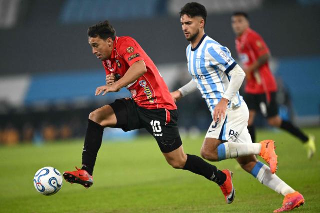 Caracas' midfielder #10 Michael Covea and Racing's defender #03 Marco Di Cesare fight for the ball during the Copa Sudamericana group stage football match between Argentina's Racing Club and Venezuela's Caracas FC at Presidente Peron 'El Cilindro' stadium in Avellaneda, Buenos Aires province, Argentina on May 21, 2026. (Photo by Luis ROBAYO / AFP)