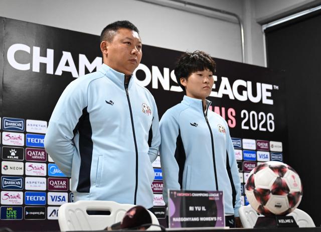 North Korea's Naegohyang Women's FC head coach Ri Yu Il (L) and his player Kim Kyong Yong (R) pose for a photo during a press conference at Suwon Sports Complex in Suwon on May 22, 2026, ahead of the AFC Women's Champions League final football match. (Photo by Jung Yeon-je / AFP)