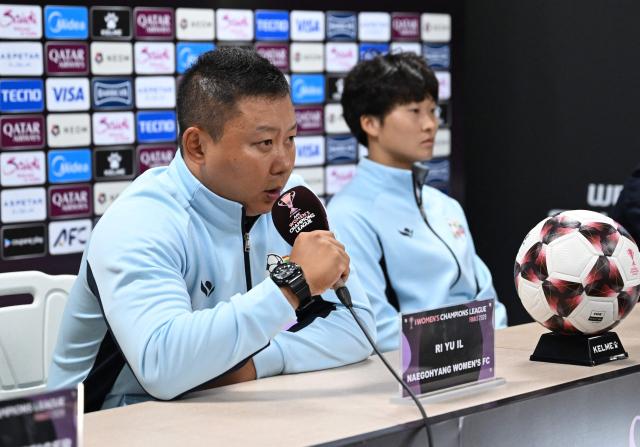 North Korea's Naegohyang Women's FC head coach Ri Yu Il (L) and his player Kim Kyong Yong (R) attend a press conference at Suwon Sports Complex in Suwon on May 22, 2026, ahead of the AFC Women's Champions League final football match. (Photo by Jung Yeon-je / AFP)
