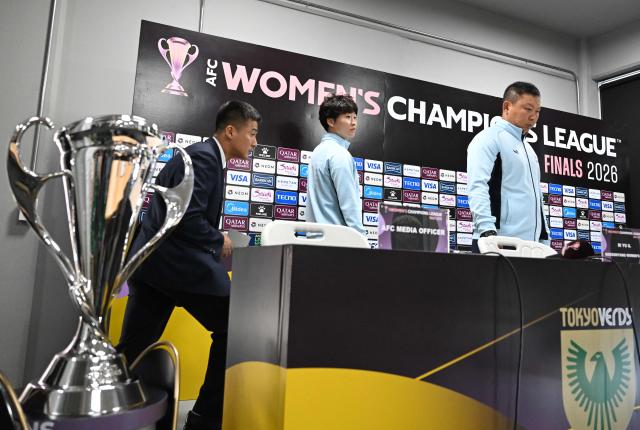 North Korea's Naegohyang Women's FC head coach Ri Yu Il (R) and his player Kim Kyong Yong (C) arrive to attend a press conference at Suwon Sports Complex in Suwon on May 22, 2026, ahead of the AFC Women's Champions League final football match. (Photo by Jung Yeon-je / AFP)