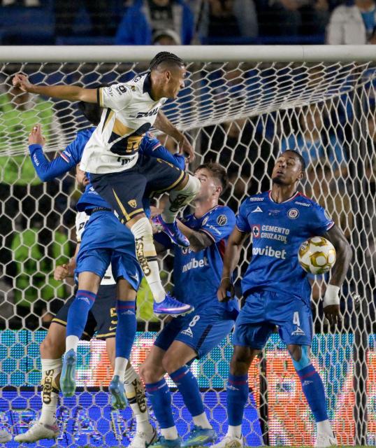 Pumas' midfielder #21 Uriel Antuna heads the ball towards Cruz Azul's Colombian defender #04 Willer Ditta during the Liga MX Clausura final first-leg football match between Cruz Azul and Pumas at the Ciudad de los Deportes Stadium in Mexico City on May 21, 2026. (Photo by Alfredo ESTRELLA / AFP)