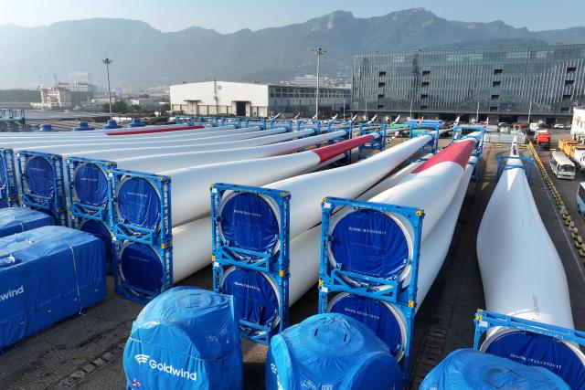 Wind turbine blades made by Goldwind are seen on a dock as they are prepared for export at the port in Lianyungang, in China’s eastern Jiangsu province on May 22, 2026. (Photo by CN-STR / AFP) / China OUT