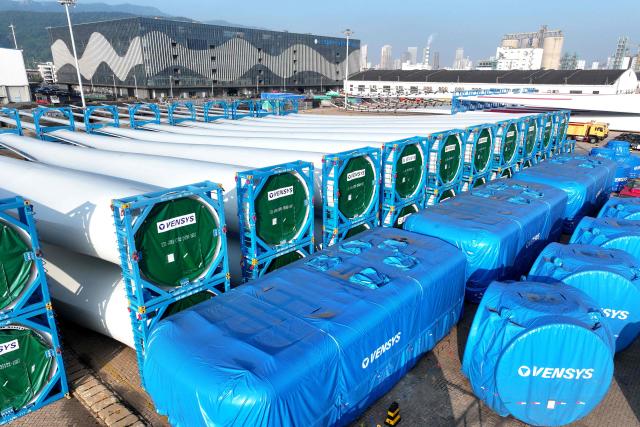 Wind turbine blades made by Vensys are seen on a dock as they are prepared for export at the port in Lianyungang, in China’s eastern Jiangsu province on May 22, 2026. (Photo by CN-STR / AFP) / China OUT