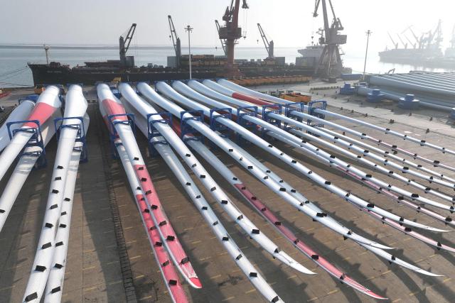 Wind turbine blades made by Goldwind and Vensys are seen on a dock as they are prepared for export at the port in Lianyungang, in China’s eastern Jiangsu province on May 22, 2026. (Photo by CN-STR / AFP) / China OUT